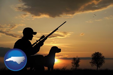 a hunter and a dog at sunset - with North Carolina icon